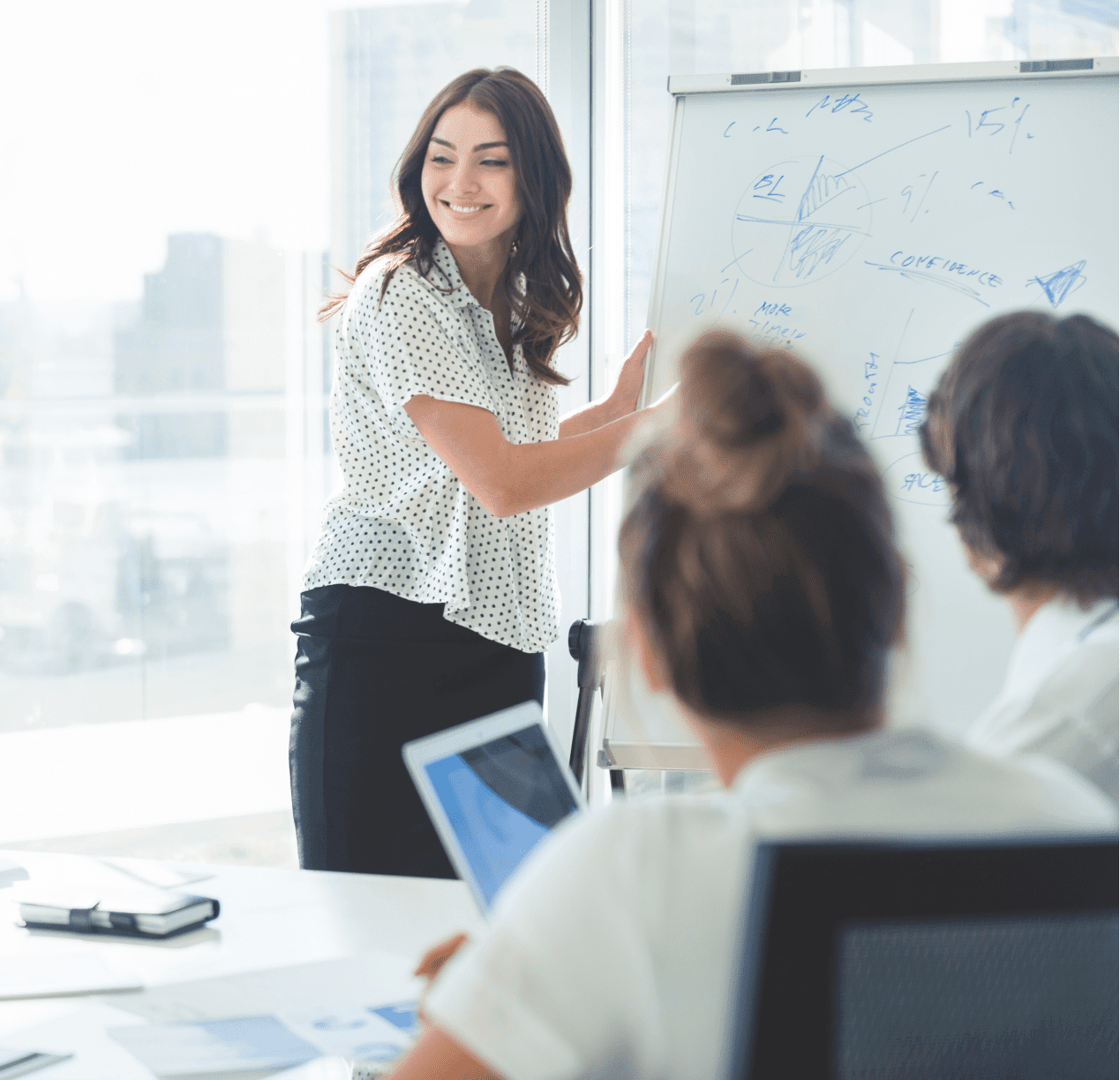 Image of female office worker leading a discussion in front of a white board in a meeting room